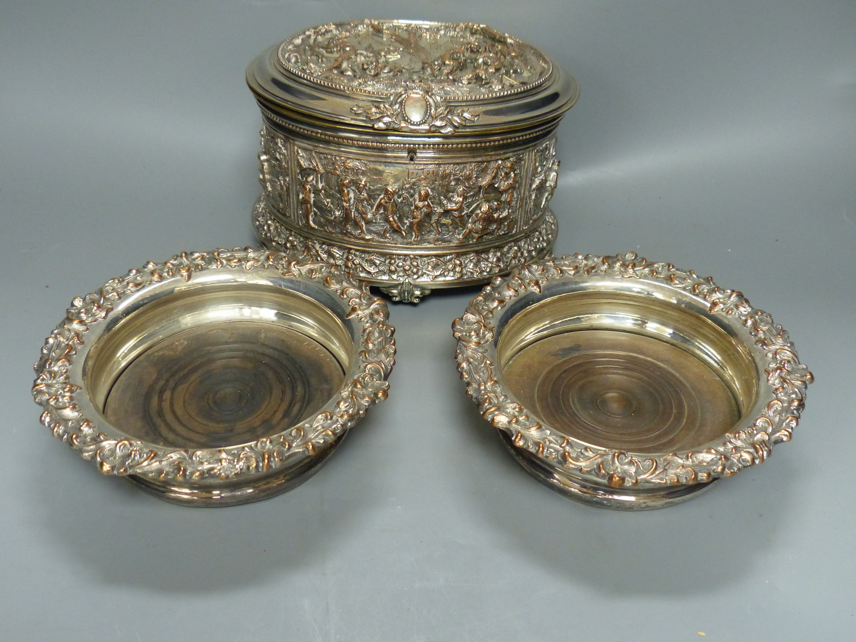 A Dutch embossed plated casket, length 19cm, and pair of plated wine coasters